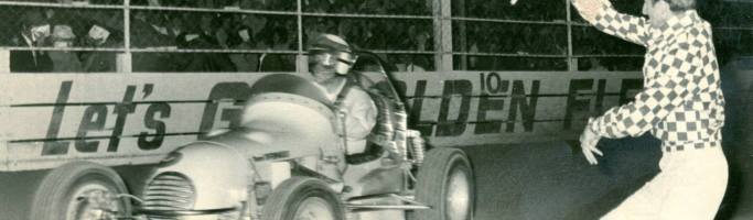 Photo thanks to 'Down Memory Lane With Noel O'Connor'. Driver Bob Wente takes the chequered flag at Rowley Park Speedway. And is that a young Glen Dix